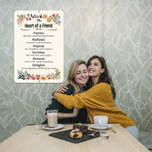 Load image into Gallery viewer, yenamic Art Heart of a Friend Metal Sign displayed in a cozy cafe with two friends embracing, symbolizing strong friendships.
