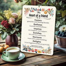Load image into Gallery viewer, Dyenamic Art Heart of a Friend Metal Sign on a rustic wooden table with flowers and tea, enhancing a heartfelt setting.
