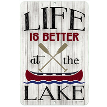 Load image into Gallery viewer, Dyenamic Art Life Is Better at the Lake Metal Sign – Rustic lake house decor featuring crossed oars, a red canoe, and distressed wood-style background for a classic waterfront look.
