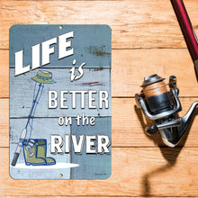 Load image into Gallery viewer, Rustic Life Is Better on the River Metal Fishing Sign displayed near a dock, adding charm to fishing cabins, boathouses, and riverfront retreats.
