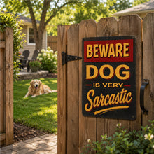 Load image into Gallery viewer, Dog lying in a garden with a humorous 'Beware Dog is Very Sarcastic' sign on a wooden gate.
