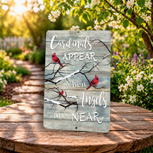 Load image into Gallery viewer, Cardinals appear when angels are near garden sign with red birds on rustic wood background displayed outdoors in a sunny flower garden.
