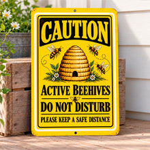 Load image into Gallery viewer, Do Not Disturb beehive warning sign mounted on a light-colored exterior wall near wooden trim and garden surroundings.
