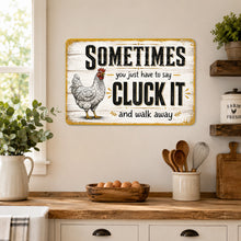 Load image into Gallery viewer, Rustic Cluck It chicken metal sign displayed on a farmhouse kitchen wall above a wood countertop with country decor

