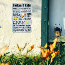 Load image into Gallery viewer, Backyard Rules Metal Sign – Displayed on a Cozy Outdoor Wall with a Basket of Flowers, Adding a Rustic and Charming Touch to Any Porch, Patio, or Backyard Gathering Space.
