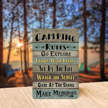 Load image into Gallery viewer, Camping Rules Metal Sign showcased at a scenic outdoor campsite with warm sunset lighting, enhancing the nature-inspired camping aesthetic.
