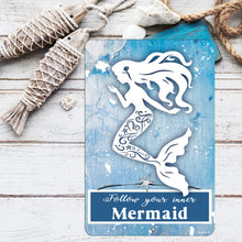 Load image into Gallery viewer, Dyenamic Art mermaid metal sign placed among nautical-themed decor, including rope-wrapped wooden fish, seashells, and weathered wood, enhancing its beach house charm.
