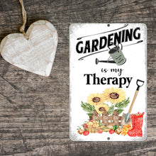 Load image into Gallery viewer, ardening Is My Therapy Metal Sign displayed on wood with farmhouse decor, perfect for garden lovers and outdoor spaces.

