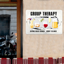Load image into Gallery viewer, The Group Therapy Metal Sign displayed on a textured brick wall, adding a playful and stylish touch to bar areas, game rooms, and entertainment spaces.
