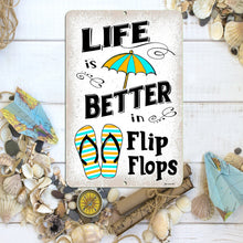 Load image into Gallery viewer, Dyenamic Art &#39;Life is Better in Flip Flops&#39; sign positioned on a sandy towel with sunglasses and beach accessories, evoking a carefree summer vibe.
