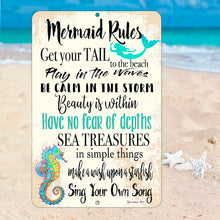 Load image into Gallery viewer, Dyenamic Art Mermaid Rules Sign placed among seashells, driftwood, and a nautical compass, blending seamlessly with ocean-inspired home décor. A charming gift for mermaid enthusiasts and beach lovers.
