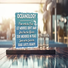 Load image into Gallery viewer, Detailed view of the Oceanology Metal Sign highlighting the textured ocean-blue background, crisp white lettering, and subtle marine-themed graphics. Designed for both indoor and outdoor use with weather-resistant aluminum construction.
