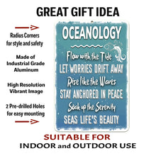 Load image into Gallery viewer, Close-up of the Oceanology Metal Sign by Dyenamic Art, showcasing the intricate white typography, wave patterns, and fish accents against a distressed blue background. Made from durable aluminum with pre-drilled holes for easy mounting indoors or outdoors.
