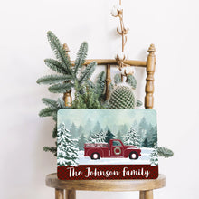 Load image into Gallery viewer, Charming farmhouse decor featuring the Personalized Red Truck Metal Sign on a rustic wooden chair, accented by winter greenery and cotton branches.
