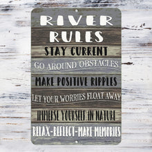 Load image into Gallery viewer, Detailed close-up of the River Rules Metal Sign, showcasing bold typography on a weathered wood-style background with inspiring phrases about nature, relaxation, and positive living.
