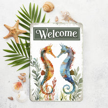 Load image into Gallery viewer, Close-up of the Dyenamic Art Seahorse Welcome Metal Sign, showing intricate watercolor details of the two seahorses and elegant typography on a rustic background.
