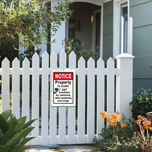 Load image into Gallery viewer, The security sign mounted on a white picket fence, warning visitors that the property is under 24/7 surveillance, adding security and peace of mind.
