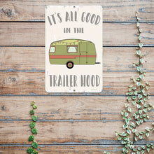 Load image into Gallery viewer, It&#39;s All Good in the Trailer Hood Metal Sign displayed on a rustic wooden surface, adding a cozy and nostalgic feel to camping and RV interiors.
