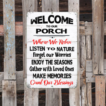 Load image into Gallery viewer, The Dyenamic Art Welcome to Our Porch sign mounted on an aged wooden fence, blending seamlessly into a rustic countryside setting.
