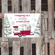 Load image into Gallery viewer, Winter Wonderland Camping Metal Sign displayed in a cozy winter setting with marshmallows and festive decorations. Ideal for RVs, cabins, and camper holiday decor.
