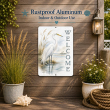 Load image into Gallery viewer, Decorative metal sign with a white egret design and 'Welcome' text, mounted on a wooden wall with plants and lantern.
