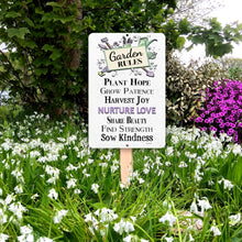 Load image into Gallery viewer, Garden Rules metal sign mounted outdoors among blooming flowers and cottage garden greenery.

