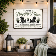 Load image into Gallery viewer, Our Happy Place farmhouse metal sign displayed on a relaxing porch with cozy seating lantern decor and sage green accents
