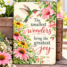 Load image into Gallery viewer, Vintage hummingbird garden sign leaning against rustic wood among pink coneflowers and colorful blooms, featuring The Smallest Wonders Bring the Greatest Joy quote.
