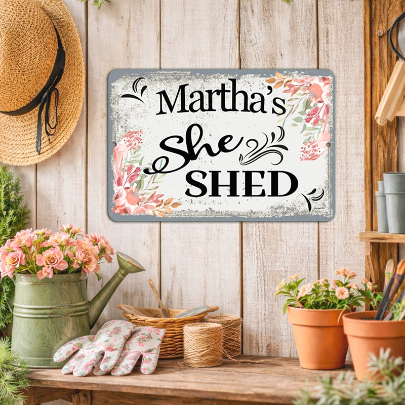 Decorative sign with 'Martha's She Shed' on a wooden wall with gardening supplies.