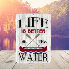 Load image into Gallery viewer, Life Is Better On the Water metal sign displayed at sunset on a dock, with trees reflecting in the calm lake water
