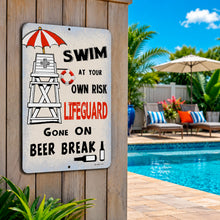 Load image into Gallery viewer, A rectangular metal sign mounted on a wooden post by a swimming pool. The sign has a weathered white background with black and red text reading 'SWIM AT YOUR OWN RISK LIFEGUARD GONE ON BEER BREAK' and includes simple illustrations of a lifeguard tower, umbrella, life preserver, bottle, and drink.
