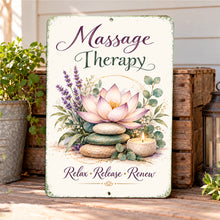 Load image into Gallery viewer, Massage Therapy metal sign leaning against a neutral wall on a wooden shelf beside rolled spa towels, eucalyptus leaves, and a glowing candle.
