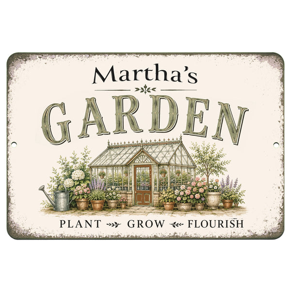 A rectangular decorative garden sign with rounded corners and pre-drilled mounting holes. The sign has a distressed cream background with the text 'Martha's GARDEN' in large dark lettering, an illustration of a greenhouse surrounded by potted plants and flowers, and the words 'PLANT GROW FLOURISH' at the bottom.