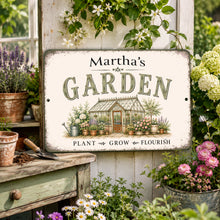 Load image into Gallery viewer, A decorative rectangular personalized garden sign reading “Martha’s GARDEN” with an illustration of a greenhouse and flowers, displayed on a rustic wooden stand in a garden setting with potted plants and flowers.
