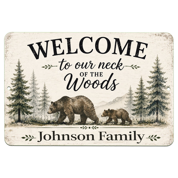 A rectangular personalized wooden-style sign with rounded corners, featuring a rustic off-white background, black text reading “WELCOME to our neck of the Woods” and “Johnson Family,” and an illustration of an adult bear, a cub, pine trees, and mountains.