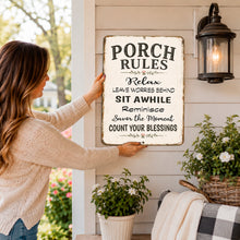 Load image into Gallery viewer, Woman holding Porch Rules farmhouse metal sign showing size and scale for porch, patio and deck decor.
