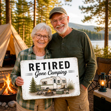 Load image into Gallery viewer, Woman holding Retired Gone Camping metal sign outdoors with cozy campground and RV lifestyle styling
