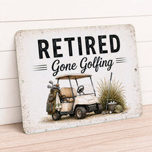 Load image into Gallery viewer, Retired Gone Golfing vintage-style metal sign with golf cart artwork displayed on rustic tabletop with farmhouse decor
