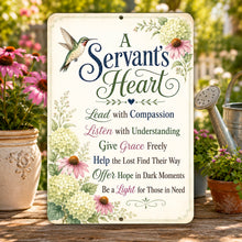Load image into Gallery viewer, A decorative metal garden sign with the words 'A Servant's Heart' and a list of service-oriented phrases, surrounded by floral illustrations. The sign is displayed on a wooden table outdoors in a garden setting with potted coneflowers, a watering can, and blurred greenery in the background.
