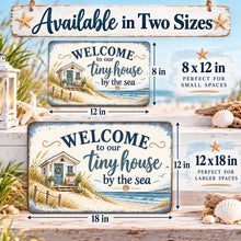 Load image into Gallery viewer, Horizontal beach cottage metal sign shown in 8 by 12 inch and 12 by 18 inch sizes with ocean scenery and tiny house welcome lettering.
