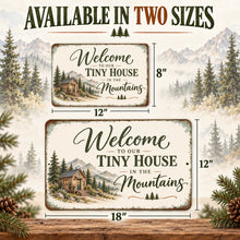 Load image into Gallery viewer, Rustic woodland welcome sign displayed in 8 by 12 inch and 12 by 18 inch sizes, featuring a tiny cabin and mountain landscape artwork.

