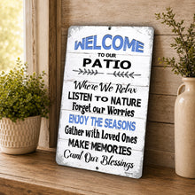 Load image into Gallery viewer, Welcome to Our Patio metal sign leaning against a rustic wall with greenery and farmhouse decor
