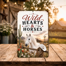 Load image into Gallery viewer, Wild Hearts &amp; Horses metal sign displayed outdoors near rustic barn in country setting
